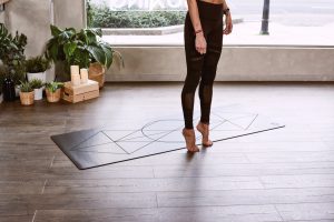 woman tip toeing on yoga mat